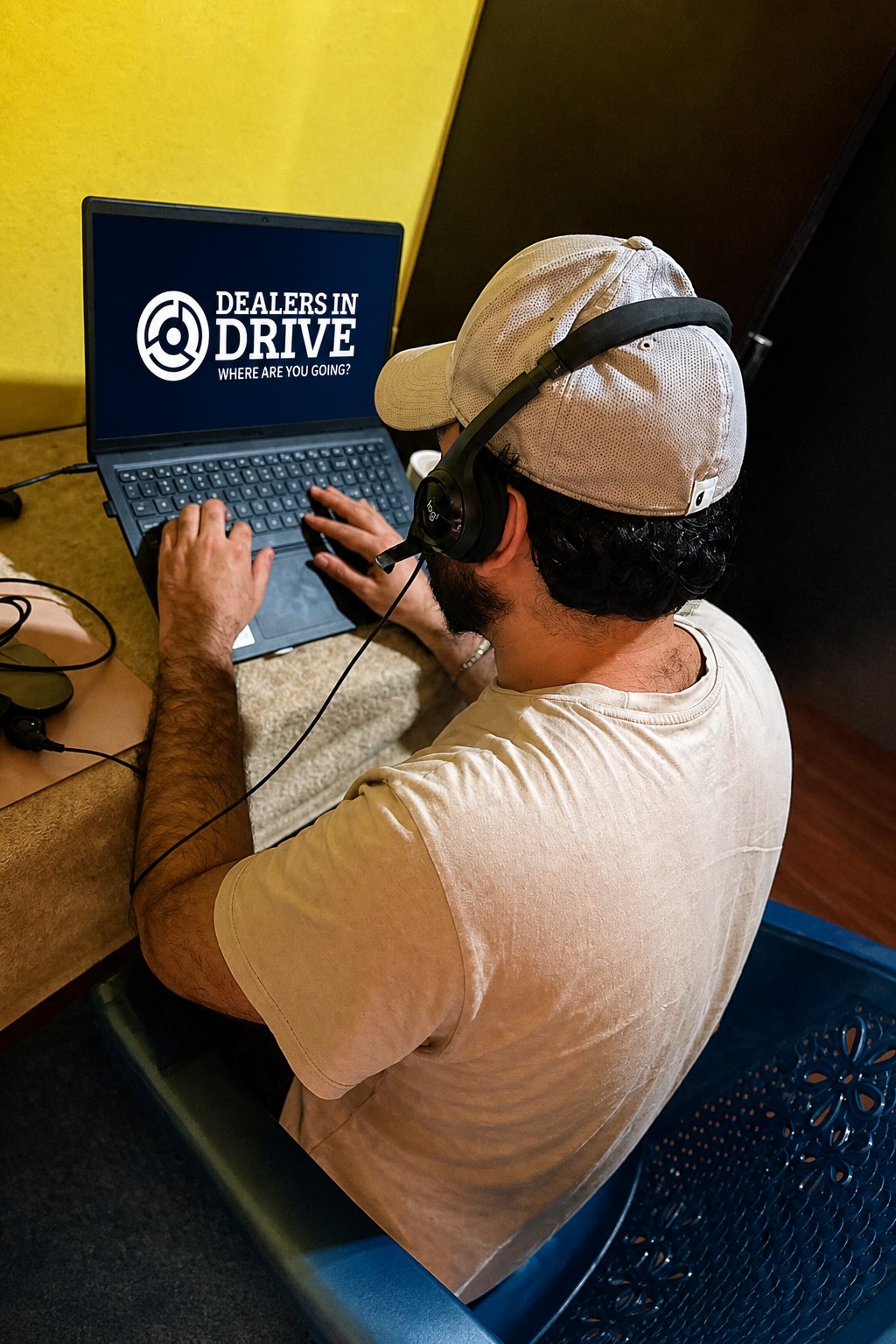 A Dealers in Drive professional working on a headset at a laptop